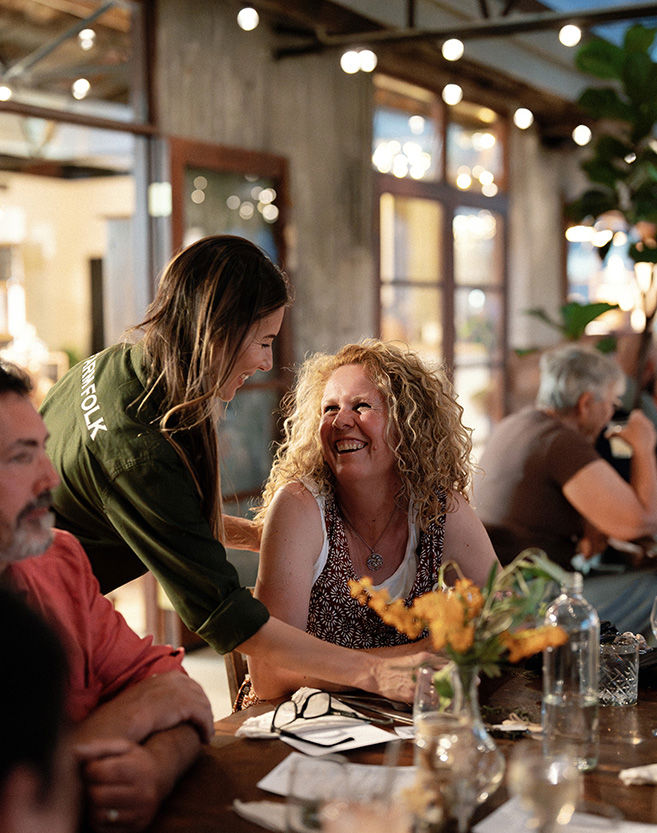 Waitress sharing a laugh with a female customer at the table